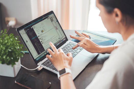 A woman working on a laptop from home, focusing on digital tasks and communication.