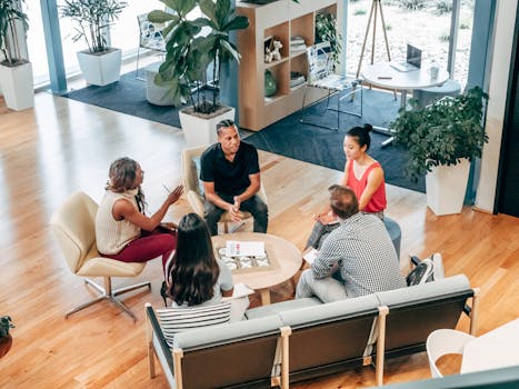 A diverse group of professionals engage in a collaborative team meeting in a stylish office environment.