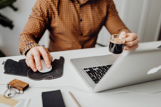 A man working from home with a coffee cup and laptop, symbolizing remote work and relaxation.