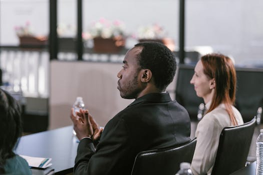 Attentive participants clapping in a business conference setting.