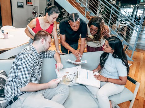 Dynamic group of colleagues brainstorming and working together in an office setting.