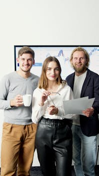 Dynamic team of young professionals collaborating in a modern office with charts in the background.