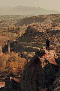 Autumn view of İncesu, Kayseri with a lone figure, capturing the rugged terrain and vibrant fall foliage.